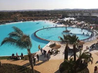 a large swimming pool with many people in it at A Coastal/island experience at a Large 2 bed apartment at a Crystal Lagoon Estate. in Pretoria
