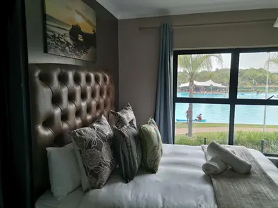 a bedroom with a bed with a view of the water at The Blyde in Pretoria