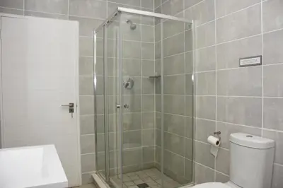 a shower with a glass door in a bathroom at The Blyde in Pretoria