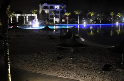 a swimming pool at night with a fountain at The Blyde in Pretoria