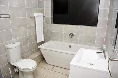 a bathroom with a toilet and a tub and a tv at The Blyde in Pretoria