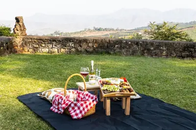 a picnic table with food and a glass of wine at Kings Walden Garden Manor in Tzaneen
