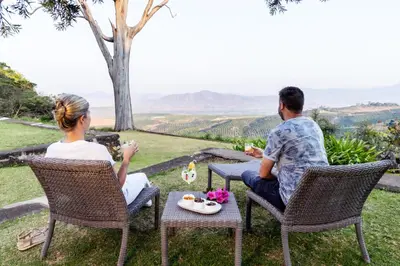 a man and a woman sitting at a table with a meal at Kings Walden Garden Manor in Tzaneen