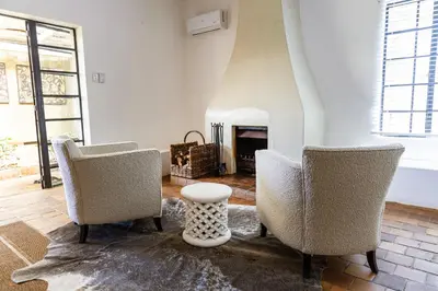 a living room with two chairs and a fireplace at Kings Walden Garden Manor in Tzaneen
