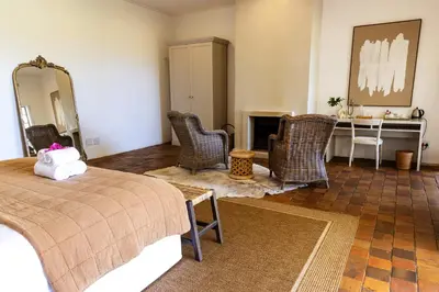 a bedroom with a bed and a table and chairs at Kings Walden Garden Manor in Tzaneen