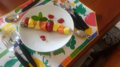 a plate with fruits and vegetables on a table at Kleineweide Boutique Estate in Pretoria