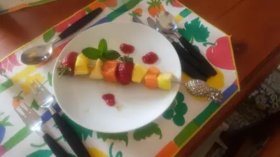 a white plate with fruit on a table at Kleineweide Boutique Estate in Pretoria