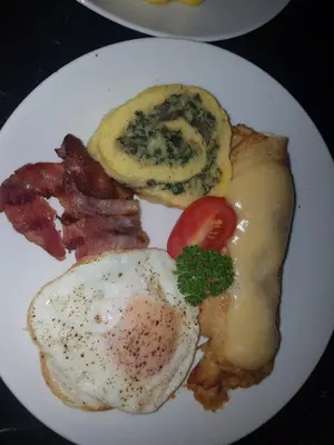 a plate of breakfast food with eggs and bacon at Kleineweide Boutique Estate in Pretoria