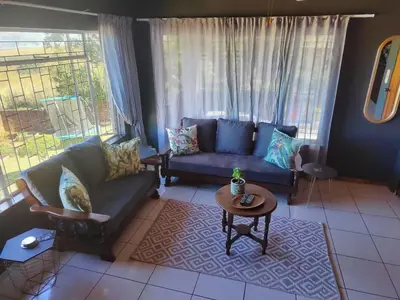 a living room with a couch and a table at Boh- House in Graskop