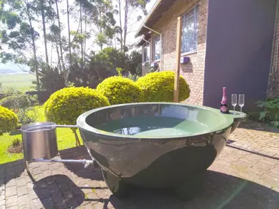 a large bath tub sitting outside of a house at Boh- House in Graskop