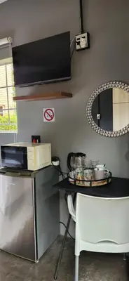 a small kitchen with a table and a microwave at Mahogany Guesthouse Mbombela in Nelspruit