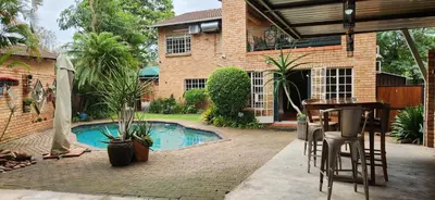 a backyard with a swimming pool and a house at Mahogany Guesthouse Mbombela in Nelspruit