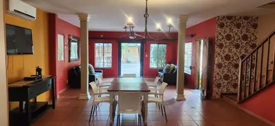 a dining room with red walls and a table and chairs at Mahogany Guesthouse Mbombela in Nelspruit