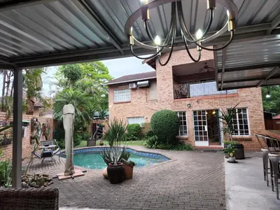 a patio with a pool and a house at Mahogany Guesthouse Mbombela in Nelspruit