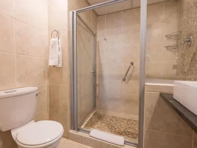 a bathroom with a shower and a toilet at ANEW Hotel Hatfield Pretoria in Pretoria
