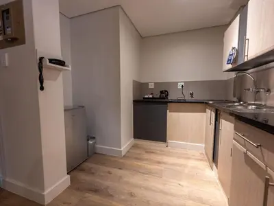 an empty kitchen with a sink and a counter at ANEW Hotel Hatfield Pretoria in Pretoria