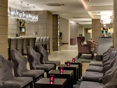 a waiting room with chairs and a bar at ANEW Hotel Hatfield Pretoria in Pretoria