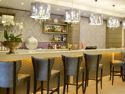 a bar in a restaurant with chairs and chandeliers at ANEW Hotel Hatfield Pretoria in Pretoria