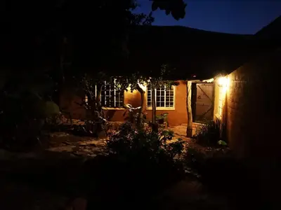 a house with a lit up door at night at OPPIBERG GUEST HOUSE and SPA in Hartbeespoort