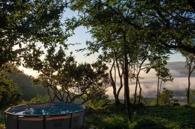 a hot tub in a field with trees at OPPIBERG GUEST HOUSE and SPA in Hartbeespoort