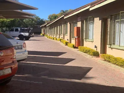 a street with cars parked next to a building at Polokwane Lodge in Polokwane