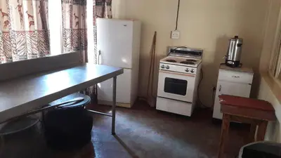 a small kitchen with a refrigerator and a stove at Echo Caves in Ohrigstad