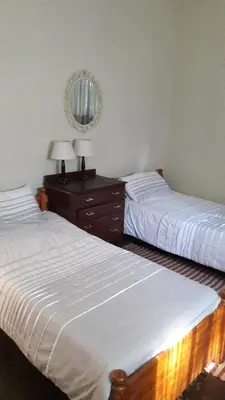 a bedroom with two beds and a dresser with a mirror at Echo Caves in Ohrigstad