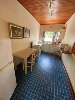a small kitchen with a table and a refrigerator at Echo Caves in Ohrigstad