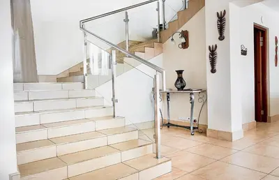 a staircase in a home with a glass railing at Zebula 8 Bedroom Lodge – IV1 in Mabula