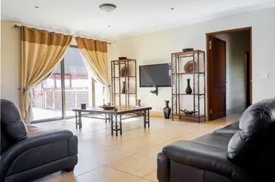 a living room with a couch and a table at Zebula 8 Bedroom Lodge – IV1 in Mabula