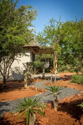 a garden in front of a building with trees at Ukuthula Bush Lodge in Hoedspruit