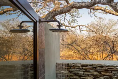 two lights hanging from a window looking out at a tree at Ukuthula Bush Lodge in Hoedspruit