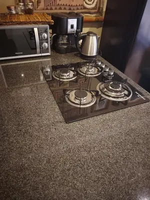 a stove top in a kitchen next to a microwave at Rockscape in Sandown