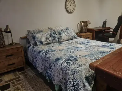 a bedroom with a bed and a clock on the wall at Rockscape in Sandown