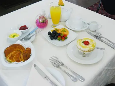 a white table topped with plates of food and drinks at Villa Jana Guesthouse in Pretoria