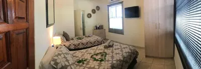 a hotel room with two beds and a television at Villa Danamara in Phalaborwa