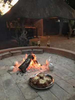 a grill with a plate of food on fire at Villa Danamara in Phalaborwa