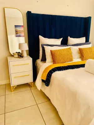 a bedroom with two beds with a mirror and a nightstand at The Blyde, an impeccable blissful getaway (Balwin properties) in Pretoria