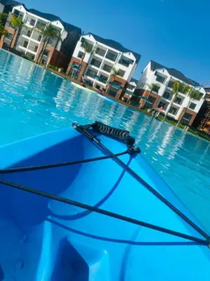 an umbrella in front of a swimming pool with buildings at The Blyde, an impeccable blissful getaway (Balwin properties) in Pretoria