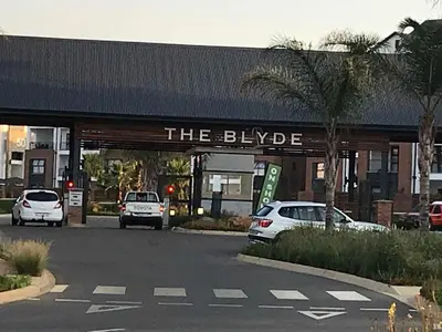 a building with cars parked in a parking lot at The Blyde, an impeccable blissful getaway (Balwin properties) in Pretoria