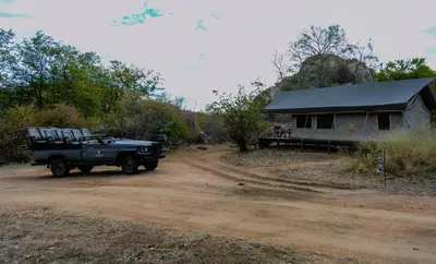 a jeep parked on a dirt road next to a building at Abelana Safari Camp in Phalaborwa