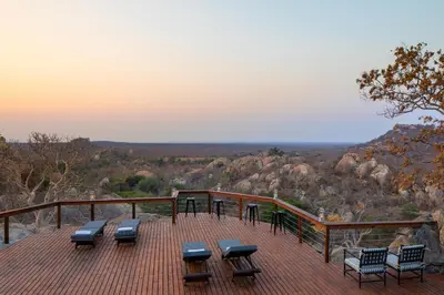 a deck with chairs and tables on top of a mountain at Abelana Safari Camp in Phalaborwa