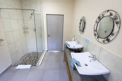 a bathroom with two sinks and a shower at Asuite-Dream in Hoedspruit