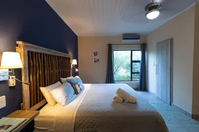 a bedroom with a bed with a teddy bear on it at Asuite-Dream in Hoedspruit