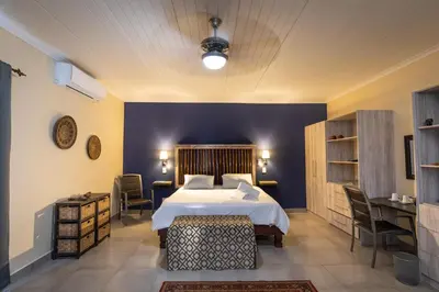 a bedroom with a bed and a blue wall at Asuite-Dream in Hoedspruit