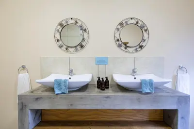 a bathroom with two sinks and mirrors on the wall at Asuite-Dream in Hoedspruit