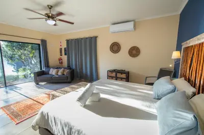 a bedroom with a large bed and a ceiling fan at Asuite-Dream in Hoedspruit