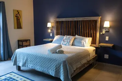 a bedroom with a large bed with blue walls at Asuite-Dream in Hoedspruit