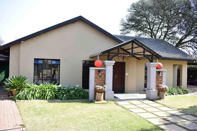 a white house with red balls on it at 13 Hobson in Secunda