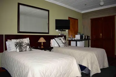 a hotel room with two beds and a mirror at 13 Hobson in Secunda
